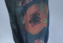 Një flamur i madh me portretet e Thaçit e Veselit vendoset në hyrje të Prishtinës